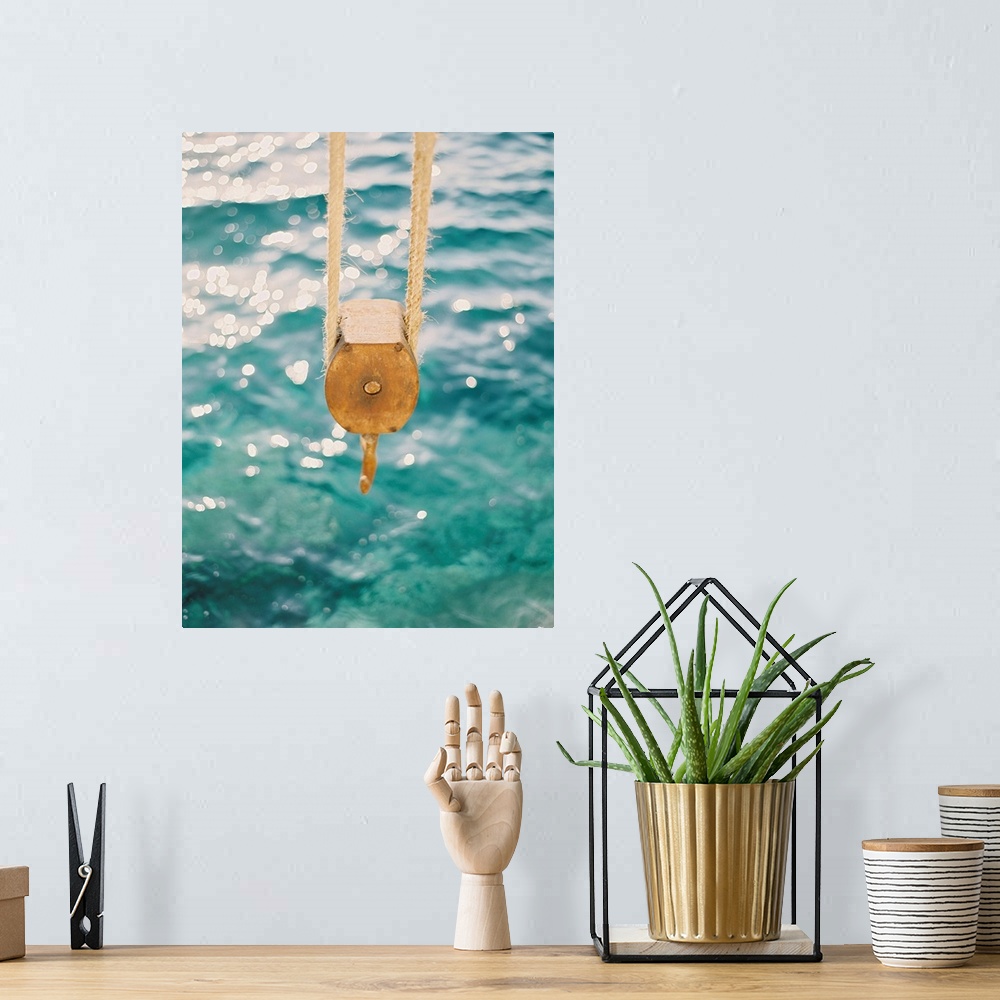 A bohemian room featuring Photograph of a tackle block hanging over the clear blue water, Santorini, Greece.