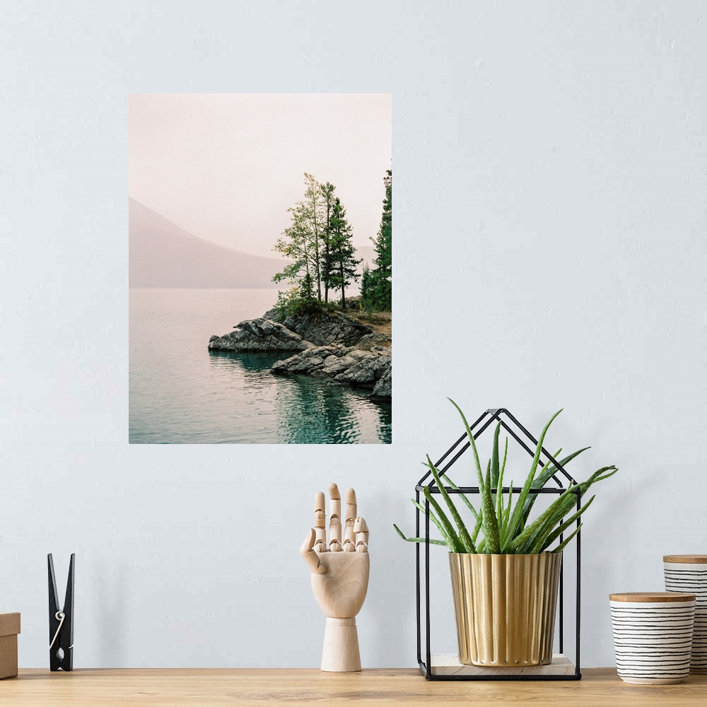 A bohemian room featuring A serene photograph of small trees on the rocky edge of a calm lake with a hazy sky.