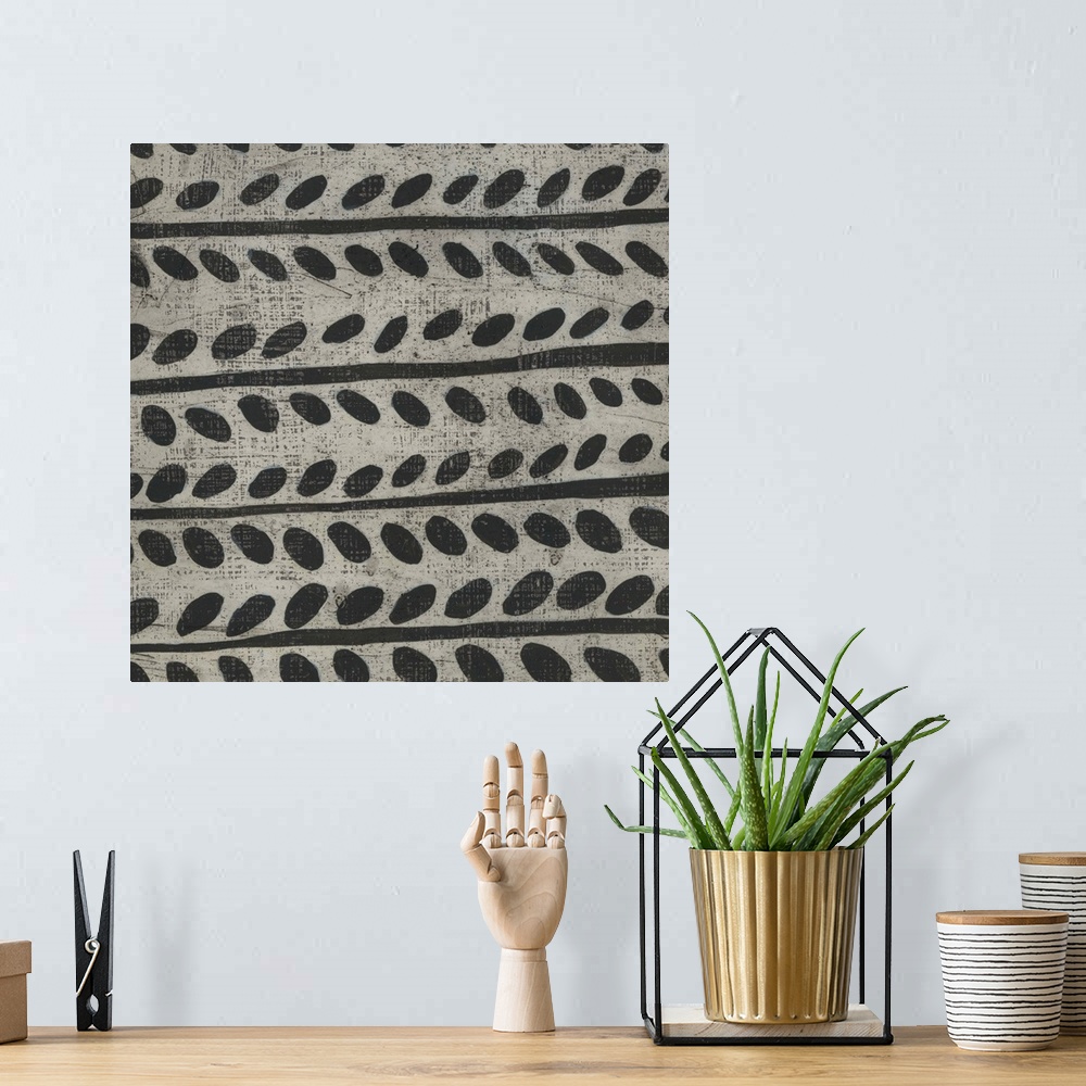 A bohemian room featuring This decorative artwork features a black and white pattern in a hand painted style with a distres...