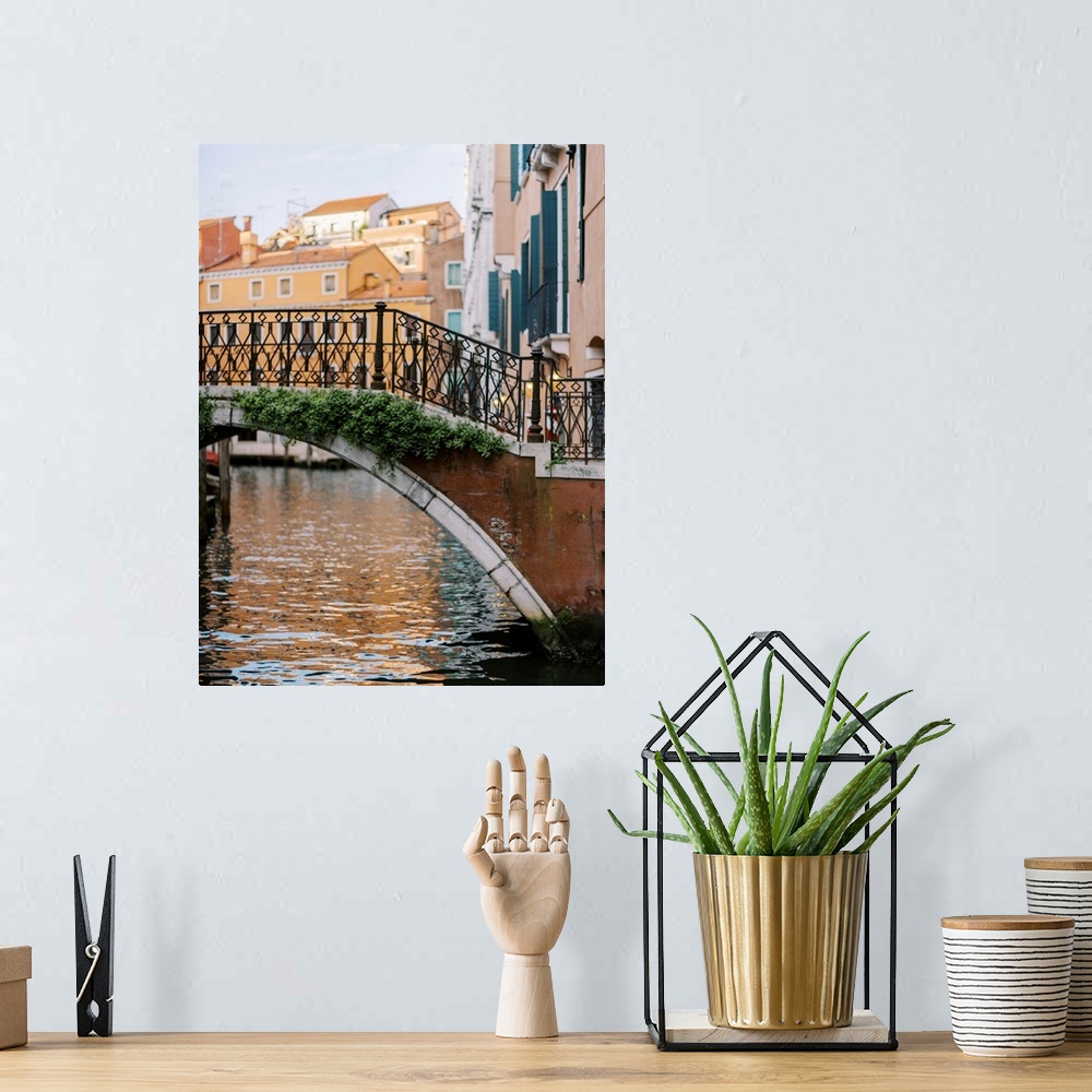 A bohemian room featuring A photograph of a beautiful wrought iron and stone bridge crossing a canal in Venice, Italy.