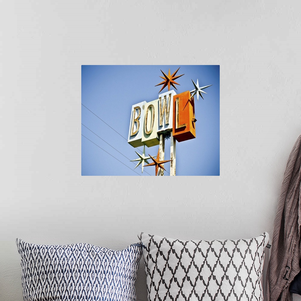 A bohemian room featuring Photograph of a retro bowling sign against a clear blue sky.
