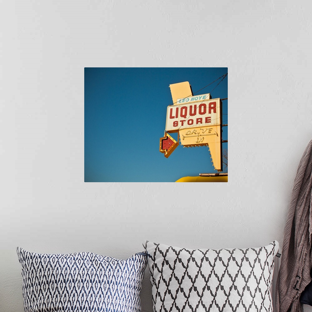 A bohemian room featuring Photograph of mid-century liquor store sign against a blue sky.