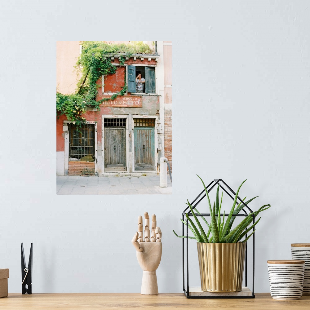 A bohemian room featuring Photograph of a woman looking out of the window of a very old building, Venice, Italy.