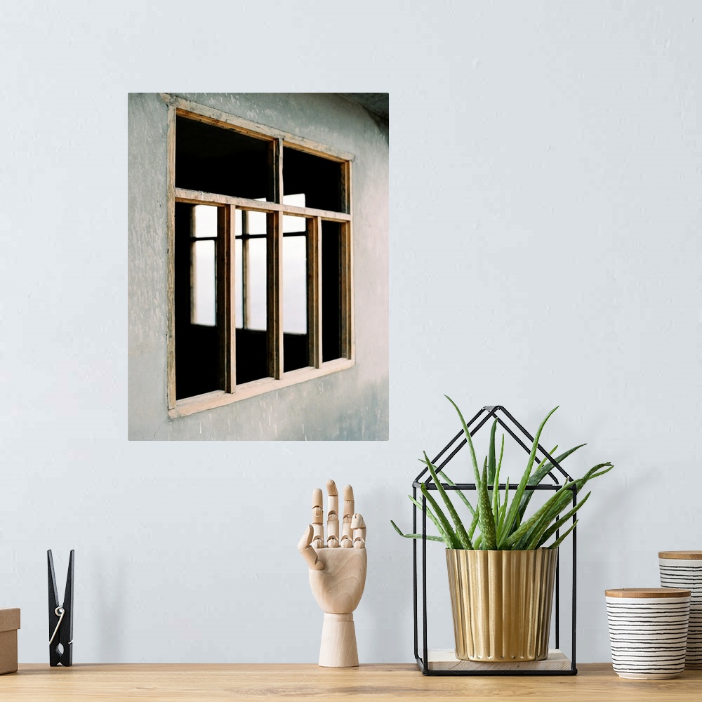 A bohemian room featuring A poetic photograph of simple wooden window frames in a stucco wall.