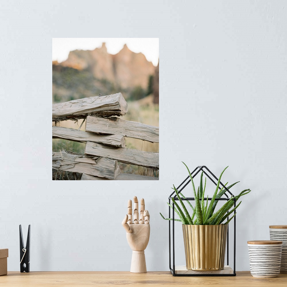 A bohemian room featuring A close up photograph of a rustic split rail fence in front of a large mountain.