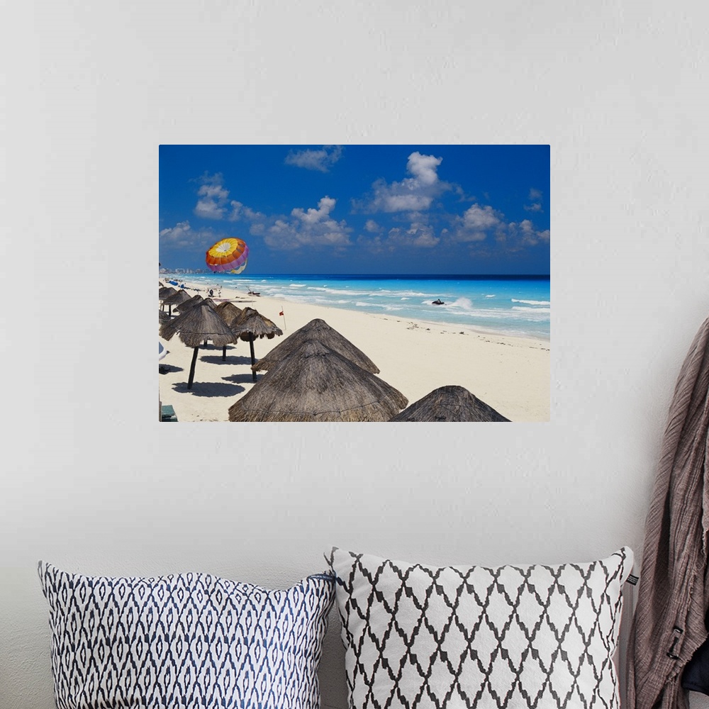 A bohemian room featuring Mexico, Cancun, sunshades along beach with parachute in background