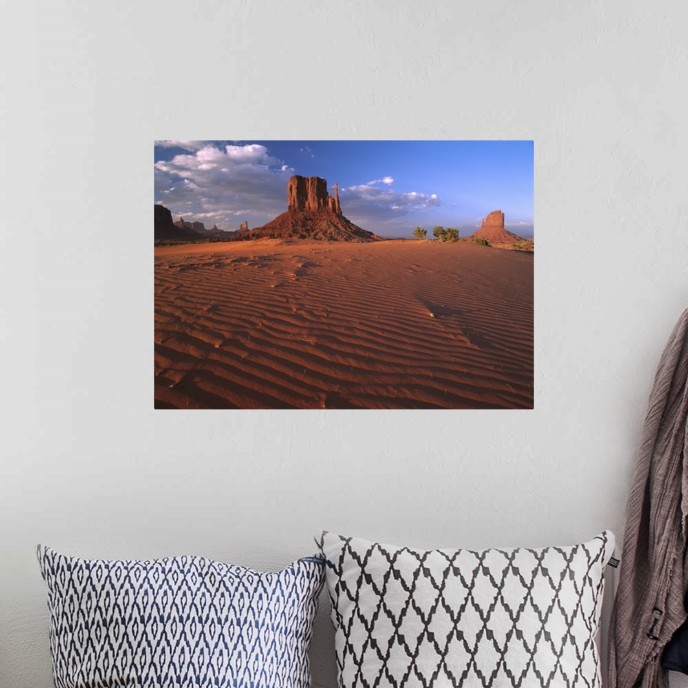 A bohemian room featuring The Mittens surrounded by rippled sand, Monument Valley Navajo Tribal Park, Arizona