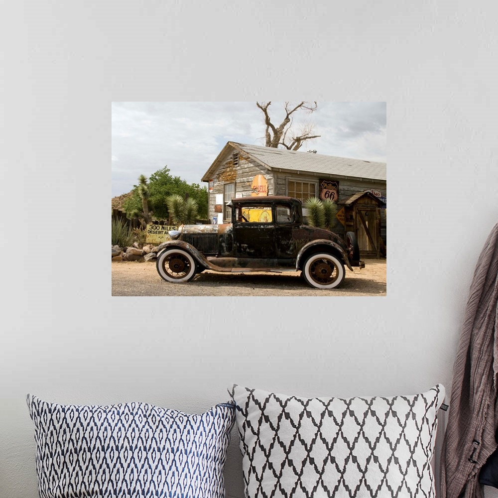 A bohemian room featuring An old rusted automobile in front of the Hackberry General Store along Route 66 in Hackberry, Ari...