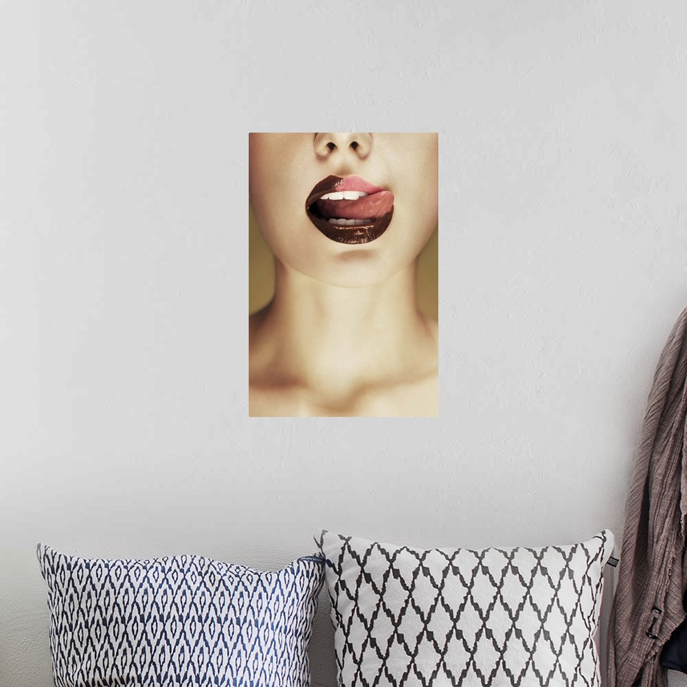 A bohemian room featuring A woman licking chocolate off of her lips with her tongue.