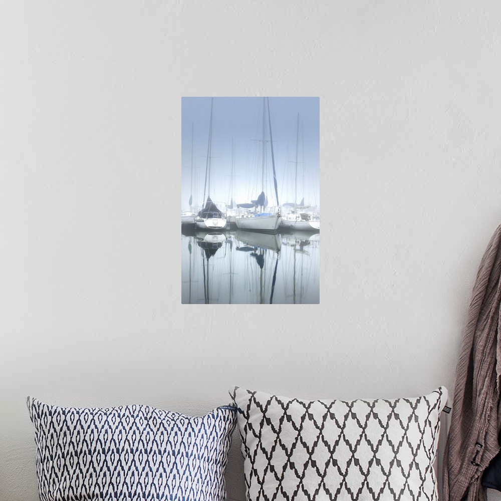 A bohemian room featuring Several sailboats on calm waters in a harbor on a foggy morning.