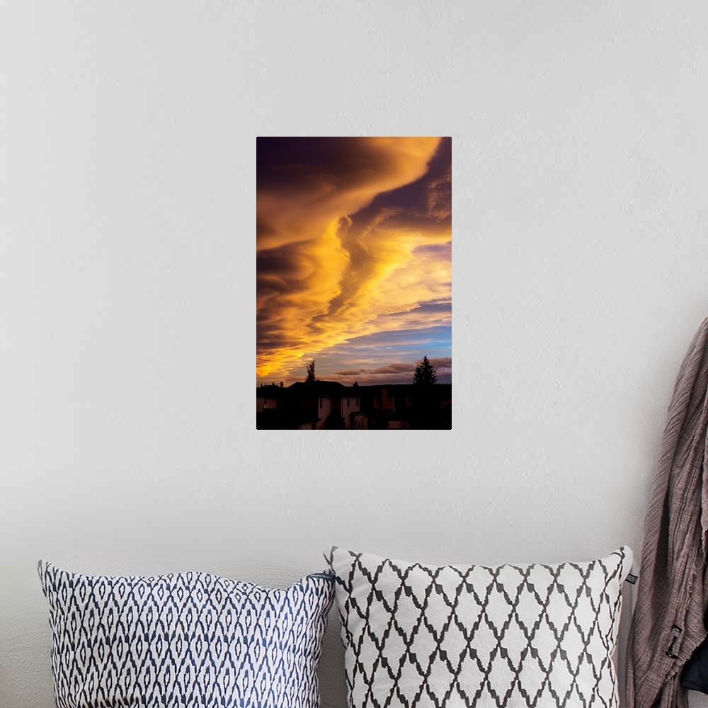 A bohemian room featuring Dramatic colourful clouds at sunset with interesting formations and some blue sky with houses in ...