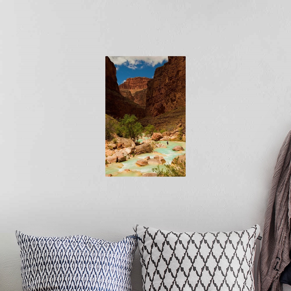 A bohemian room featuring Hiker walking in the turquoise waters of Havasu Canyon.