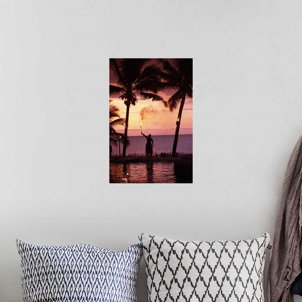 A bohemian room featuring Native In A Grass Skirt Holding A Flaming Torch By Coast At Sunset