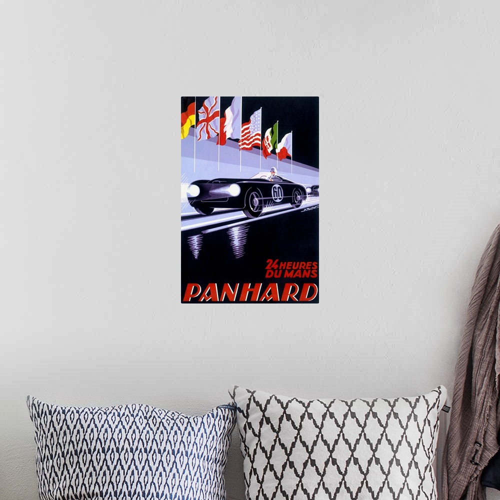 A bohemian room featuring A vertical piece of artwork of a black car racing with flags above it and red text below with the...