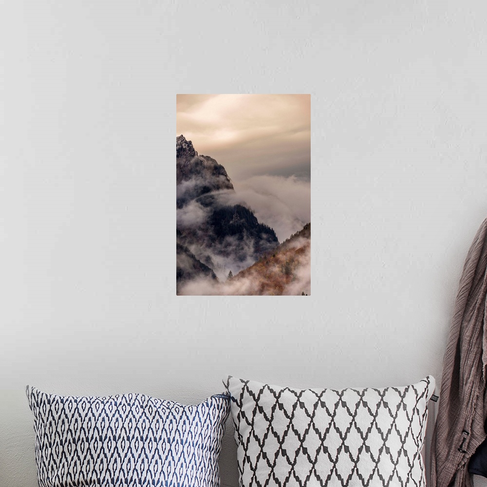 A bohemian room featuring Landscape photograph of foggy mountain cliffs.