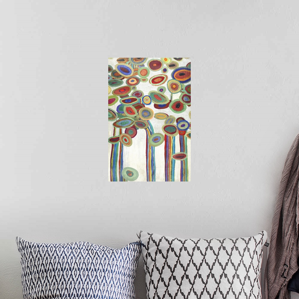 A bohemian room featuring Vertical painting of a group of multi-colored circles against a neutral backdrop.