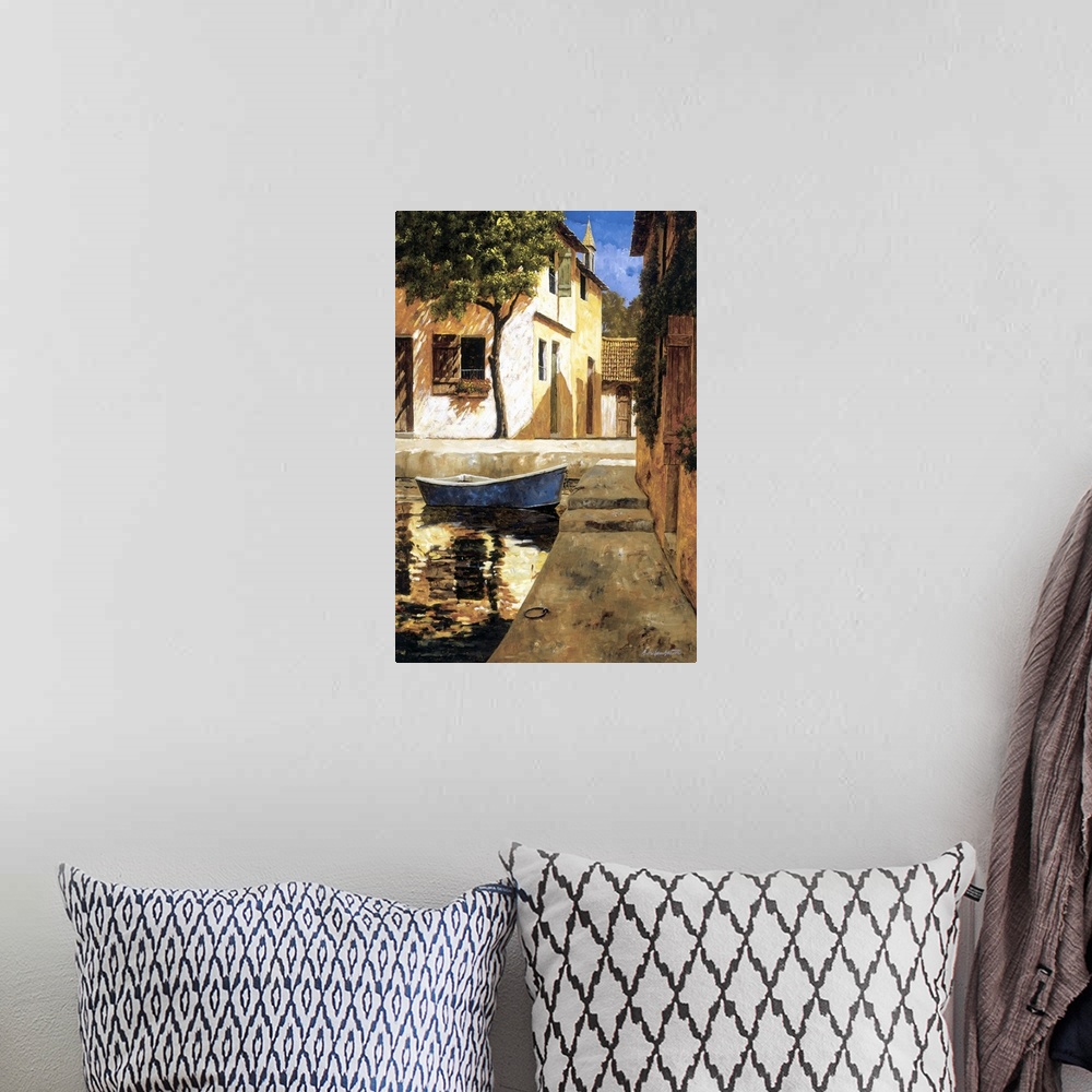 A bohemian room featuring Painting of a boat docked near stairs in a European village.