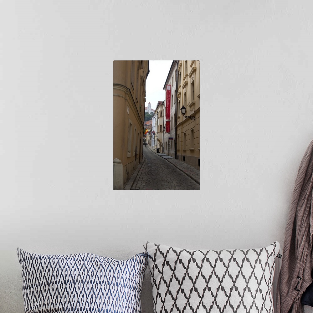 A bohemian room featuring Slovakia, Bratislava. Narrow street in historic district with view of Bratislava Castle in distance.