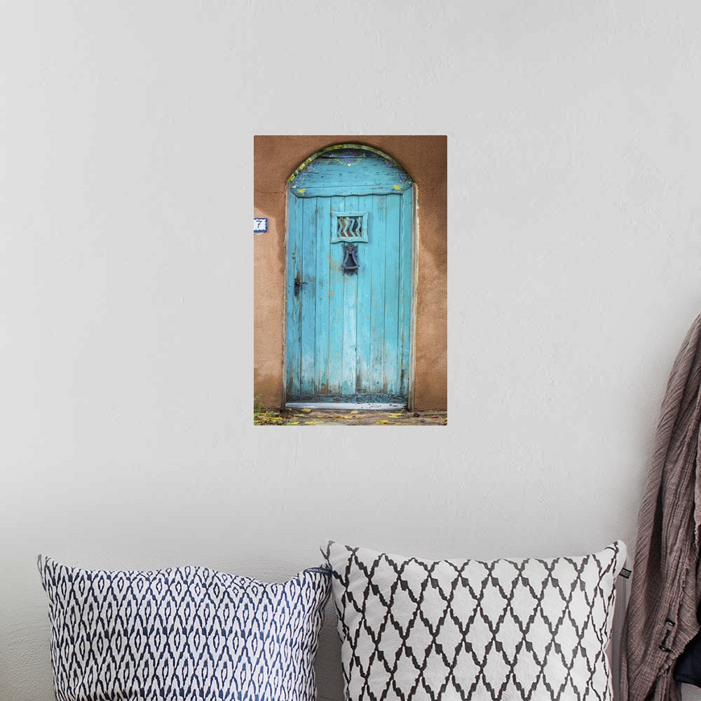 A bohemian room featuring Photograph of a bright blue door in an adobe wall.