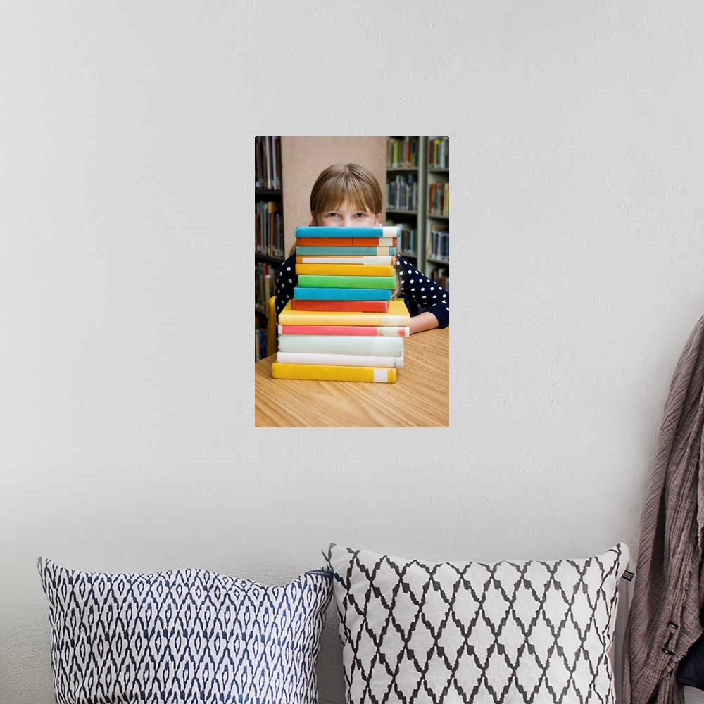 A bohemian room featuring Girl looking over stack of books