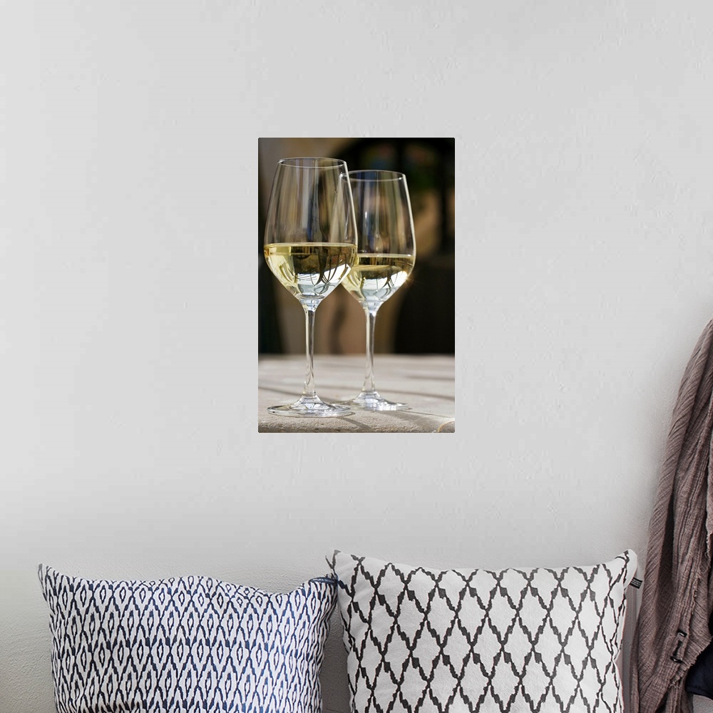 A bohemian room featuring Up-close photograph of two champagne glasses half full on concrete table.