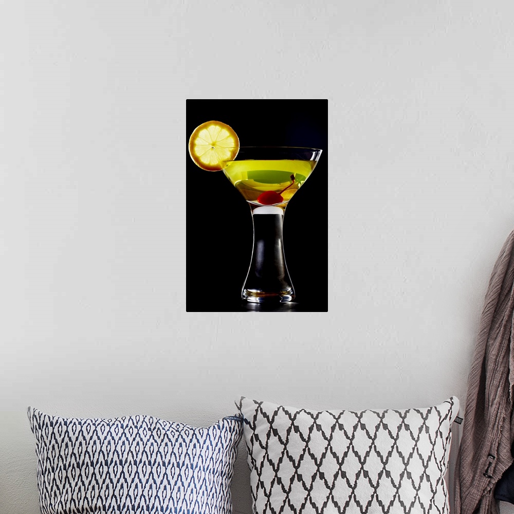 A bohemian room featuring Green coloured cocktail with cherry and orange slice, close-up