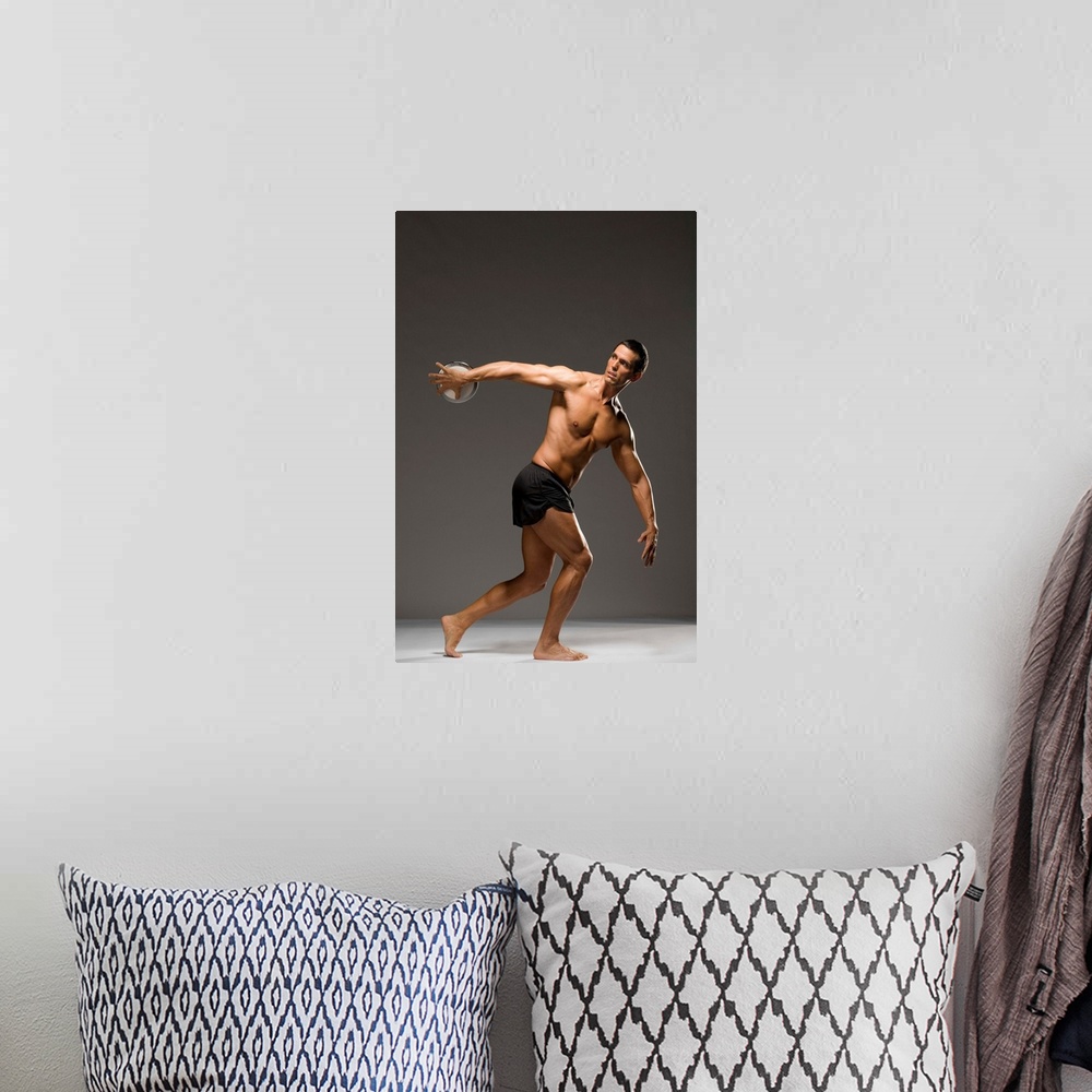 A bohemian room featuring Male athlete throwing discus, studio shot