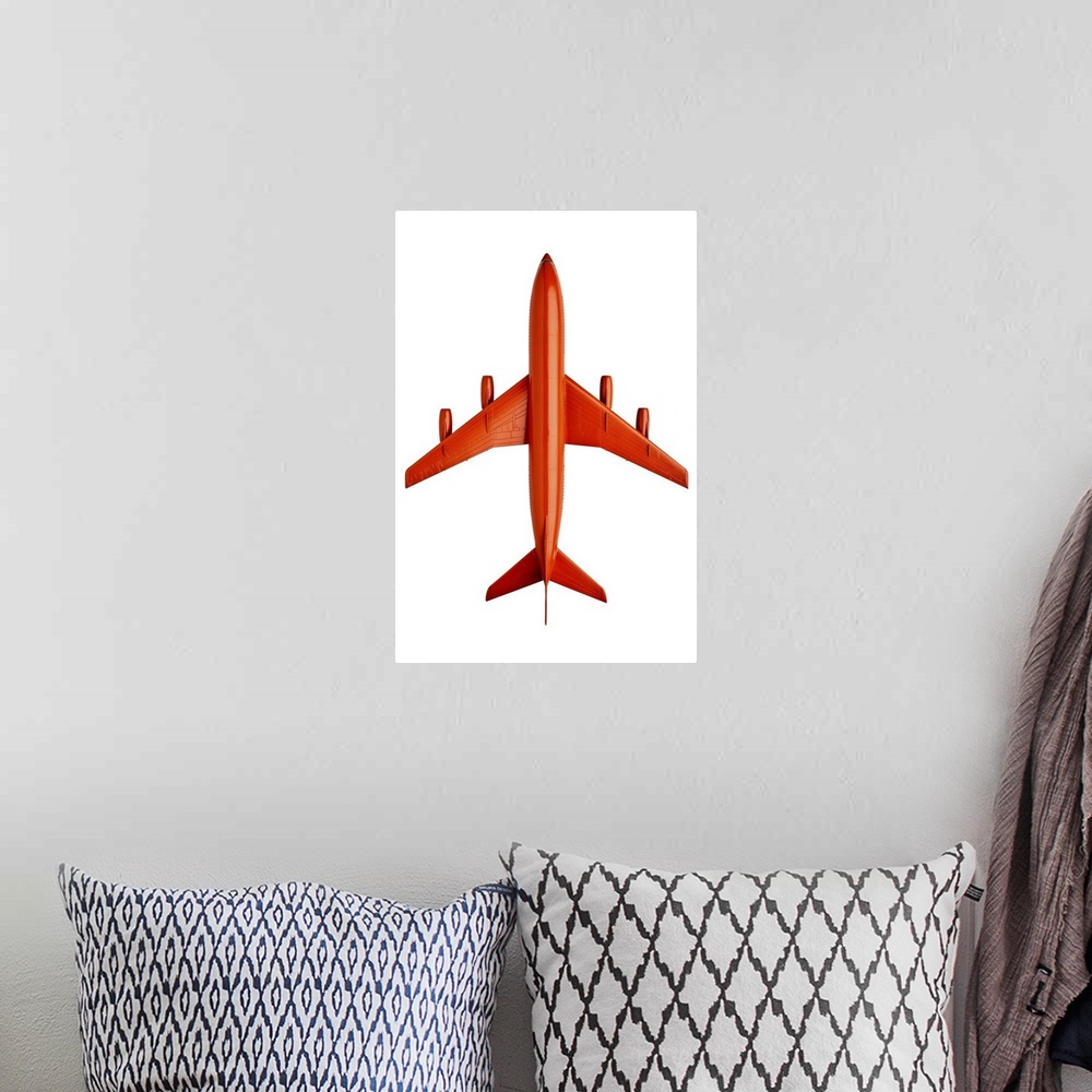 A bohemian room featuring Orange plastic model of an airliner / plane, on white background, cut out