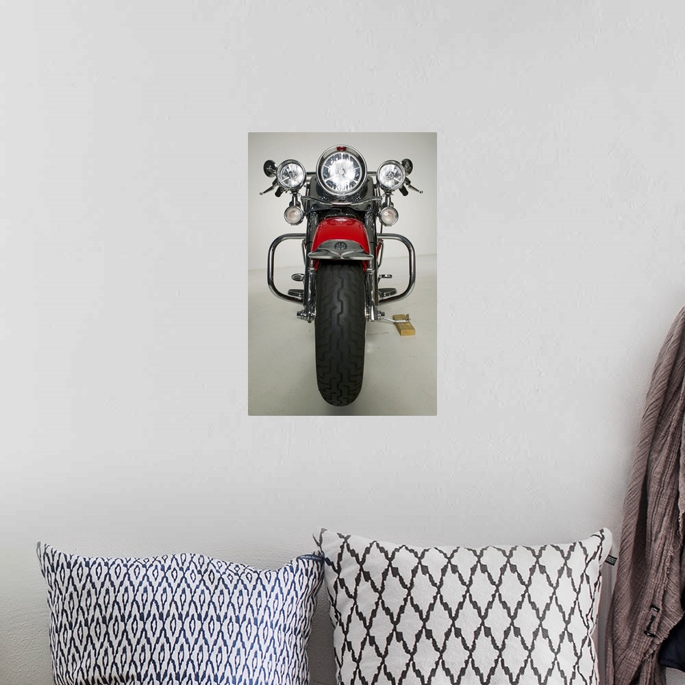 A bohemian room featuring Vertical photo on canvas of a vintage motorcycle seen from the front.
