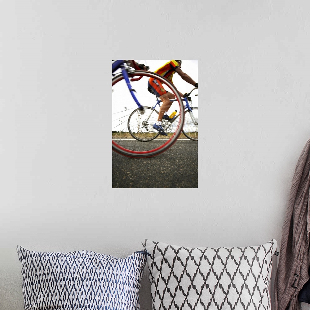 A bohemian room featuring Cyclist speed by and a picture is snapped of the front tire of the cyclist closest and the person...