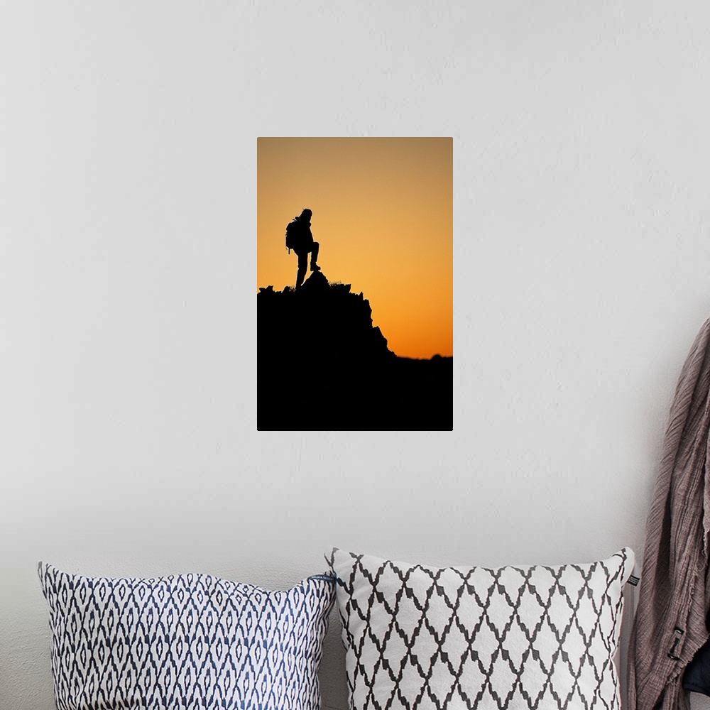 A bohemian room featuring Silhouette of hiker standing on peak at sunset