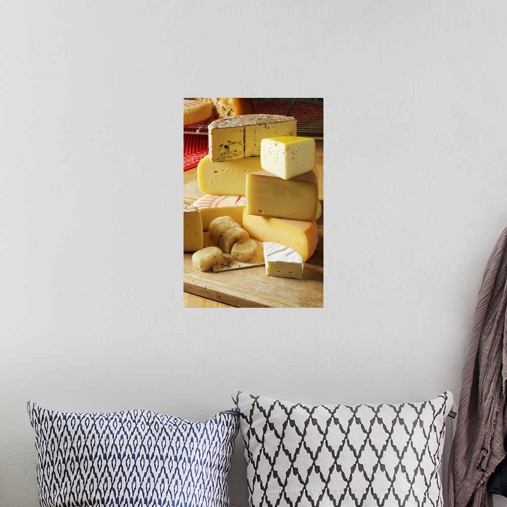 A bohemian room featuring Big, vertical photograph of stacks of assorted light yellow and white cheeses, sitting on a woode...
