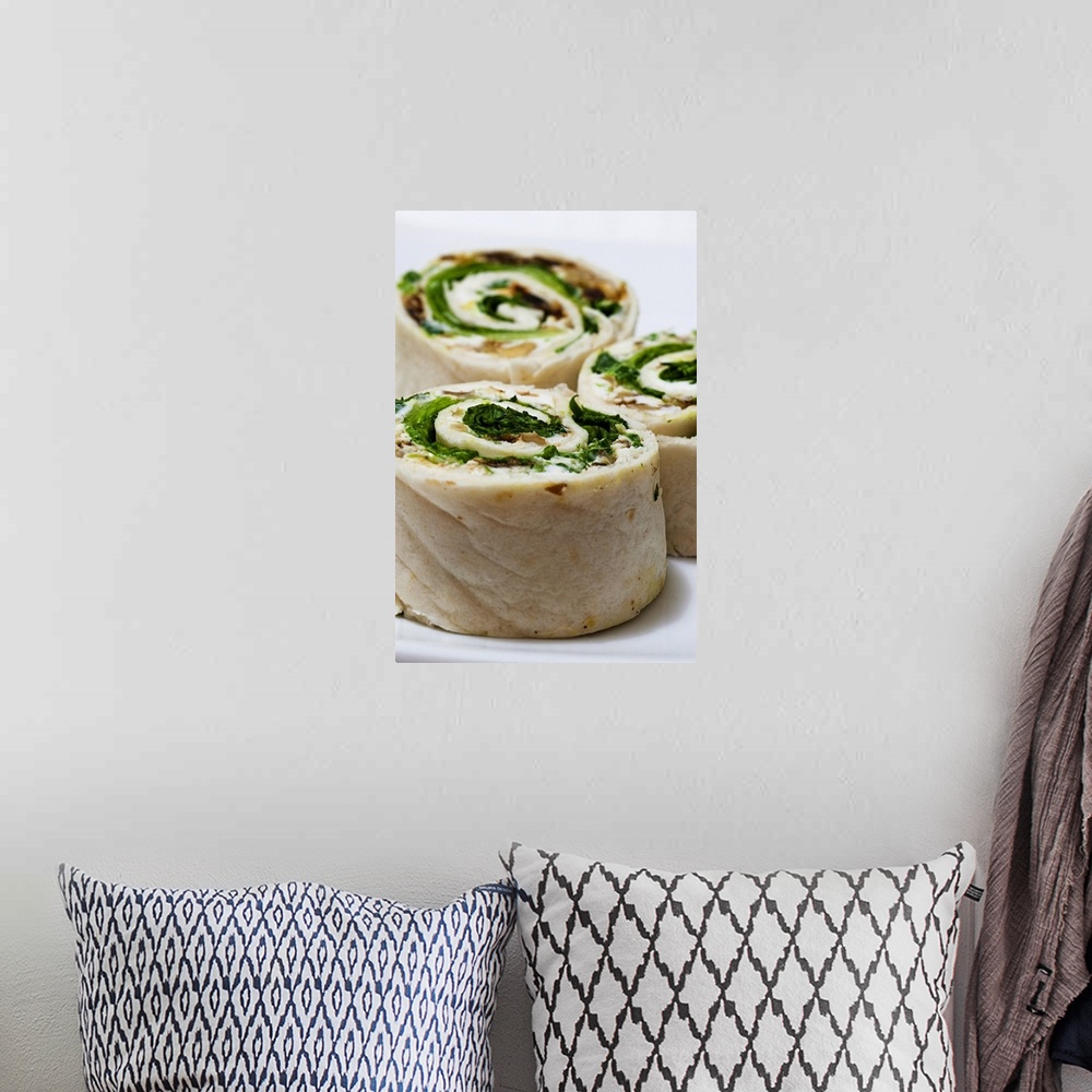A bohemian room featuring Tortilla rolls filled with goat's cheese and salad, close-up