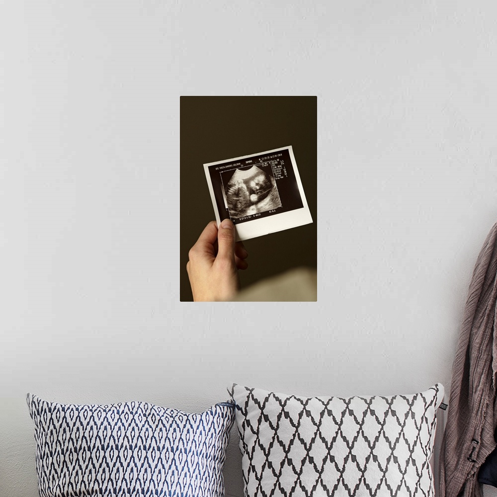 A bohemian room featuring Woman holding ultrasonograph photo of baby