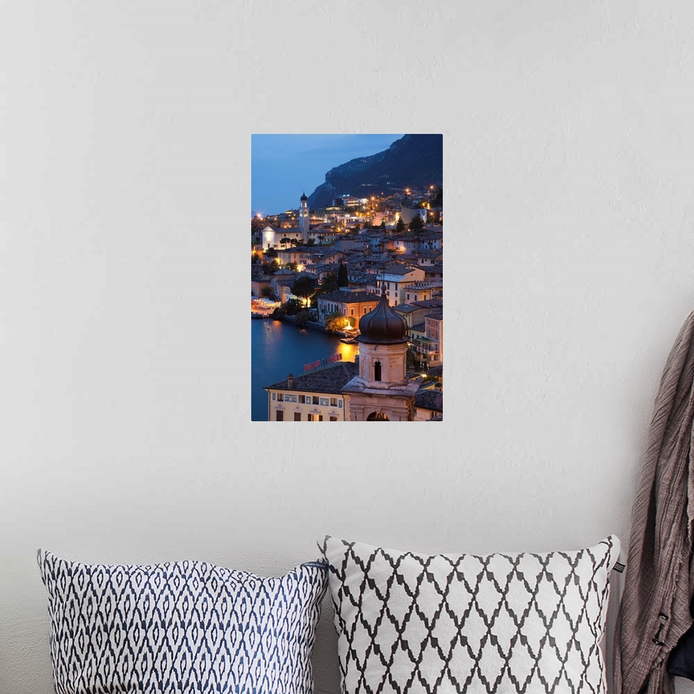 A bohemian room featuring Italy, Lombardy, Lake District, Lake Garda, Limone sul Garda, aerial town view, dusk