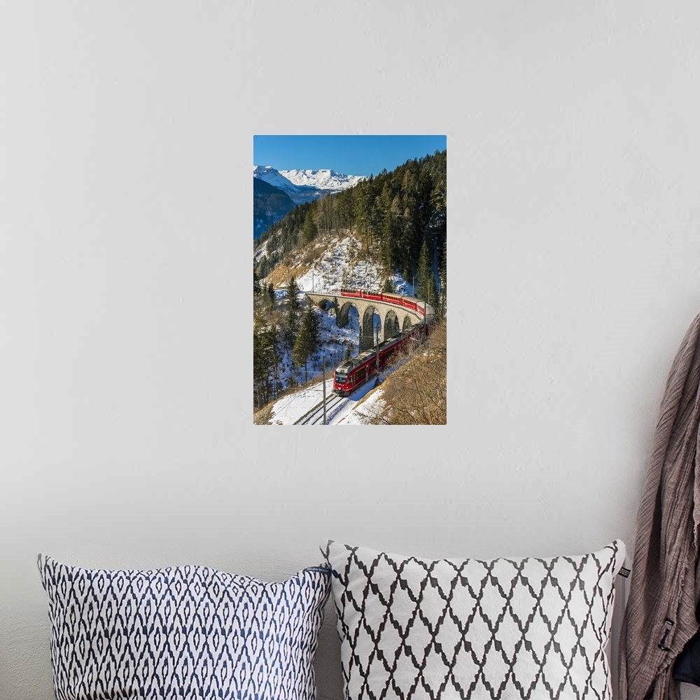 A bohemian room featuring The famous red train of Albula mountain railway passing through a scenic winter alpine landscape ...