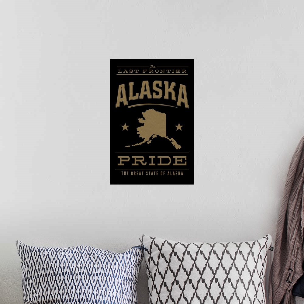 A bohemian room featuring The Alaska state outline on black with gold text.