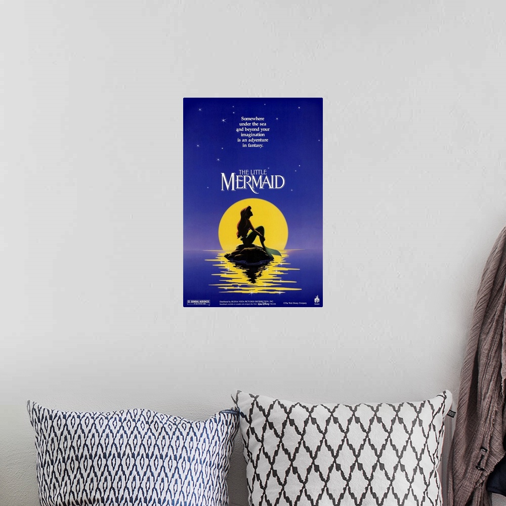 A bohemian room featuring Poster for the classic Disney movie "The Little Mermaid". Ariel sits on a rock in the ocean in fr...