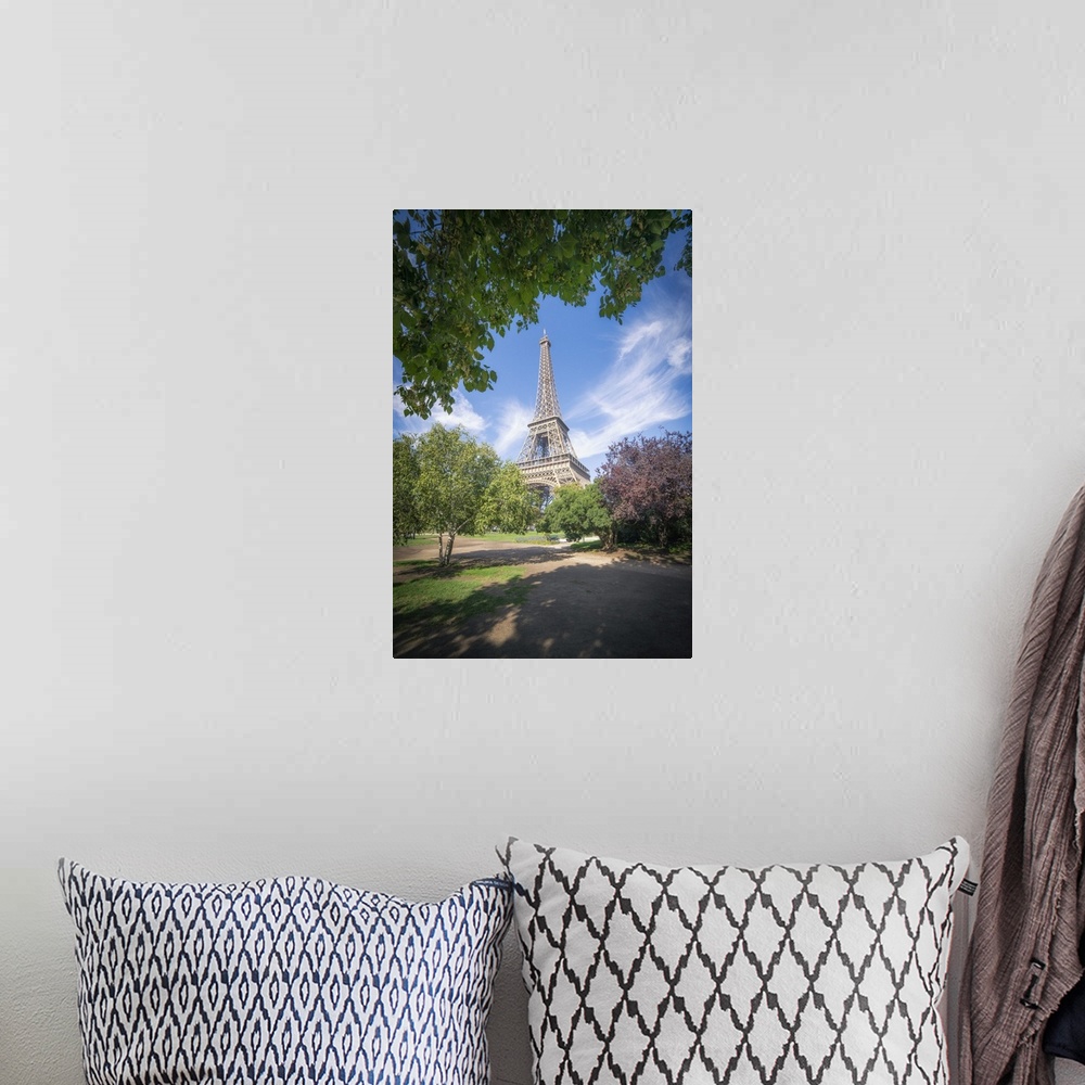 A bohemian room featuring Eiffel tower view from Champ de mars in Paris, France among trees and garden on summer under a bl...