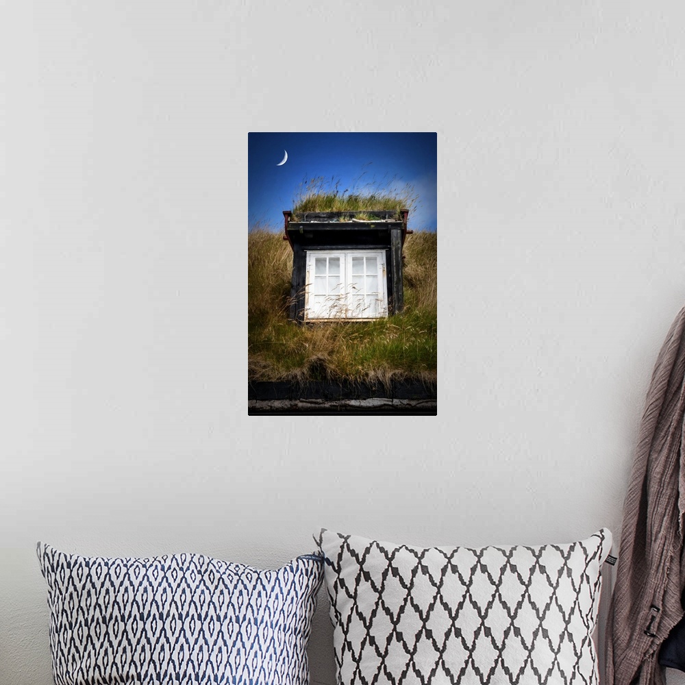A bohemian room featuring Crescent moon over a window in the grassy roof of a house.