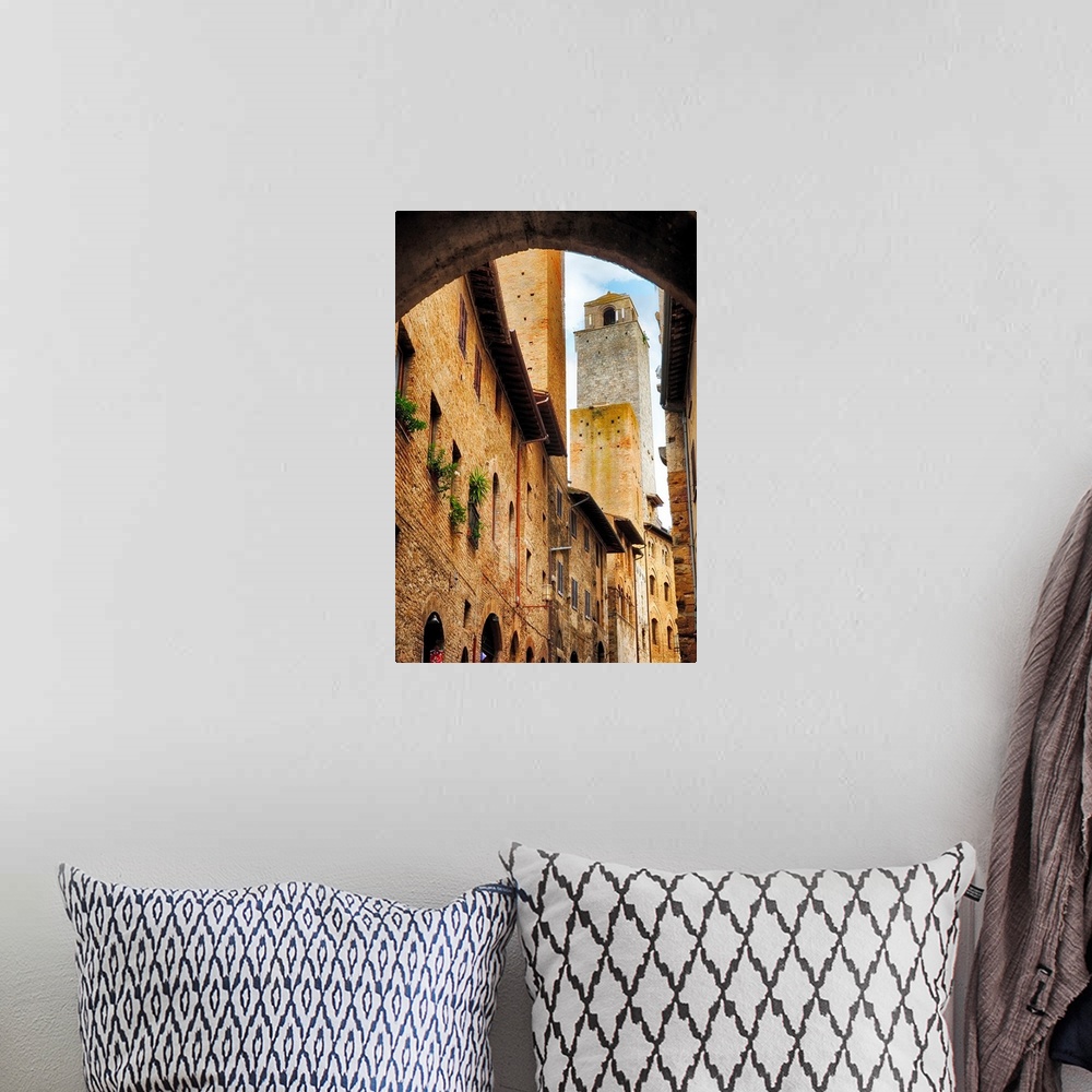 A bohemian room featuring A photograph of stone buildings and tower in Italy.