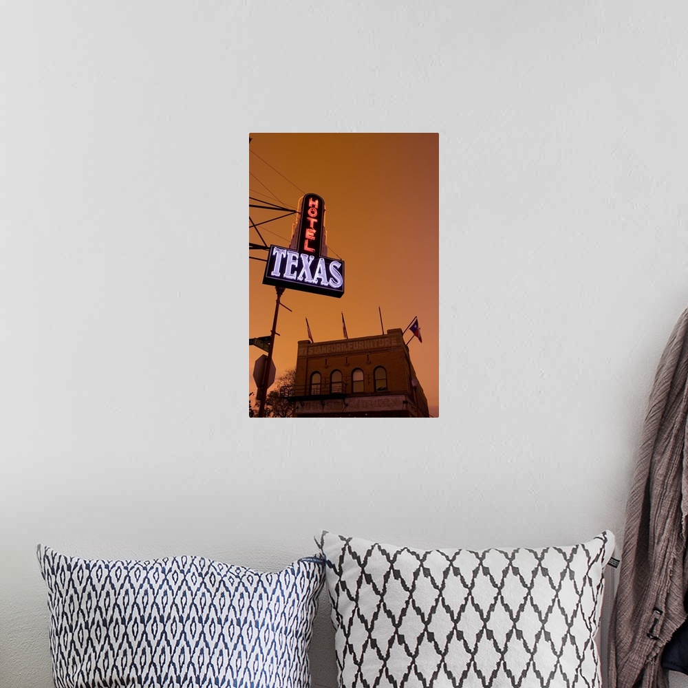 A bohemian room featuring A hotel sign is illuminated under a sunset sky and photographed from below with a view of a furni...