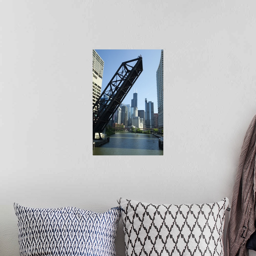 A bohemian room featuring Vertical wall docor of a big bridge raising up on the Chicago River with the Willis Tower in the ...