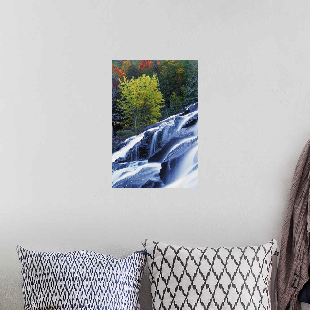 A bohemian room featuring Tall photo on canvas of water rushing down a large waterfall with fall foliage in the background.