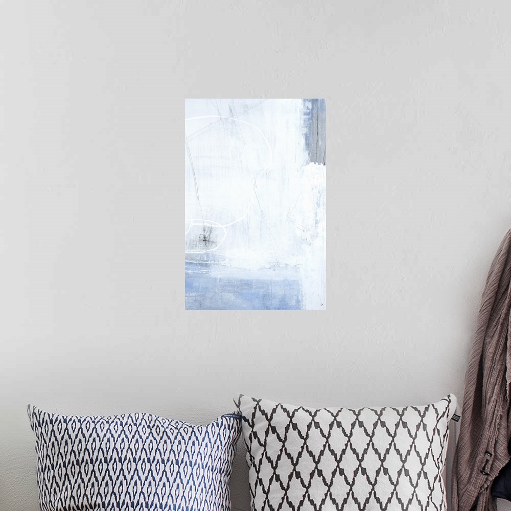 A bohemian room featuring A long vertical painting of washed colors of gray and blue with dripped paint textures and swirle...