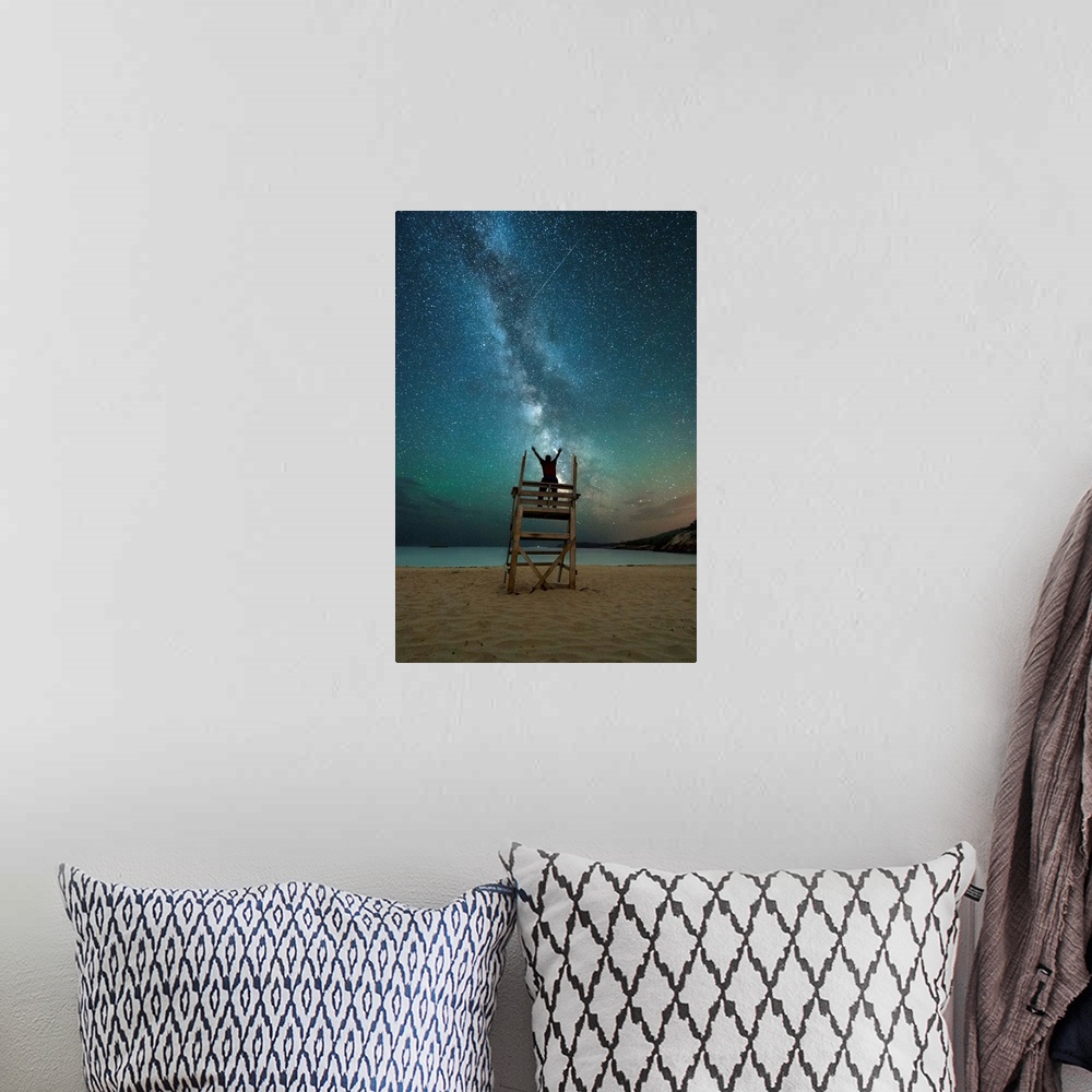 A bohemian room featuring A photograph of a person on a lifeguard tower under a blanket of star in the night sky.
