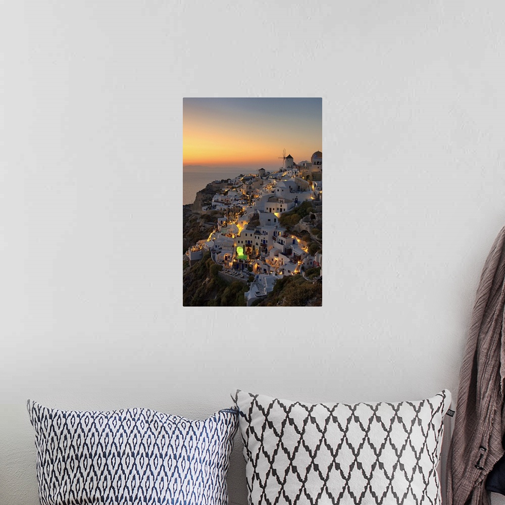 A bohemian room featuring The village of Oia on Santorini illuminated at sunset, Greece.