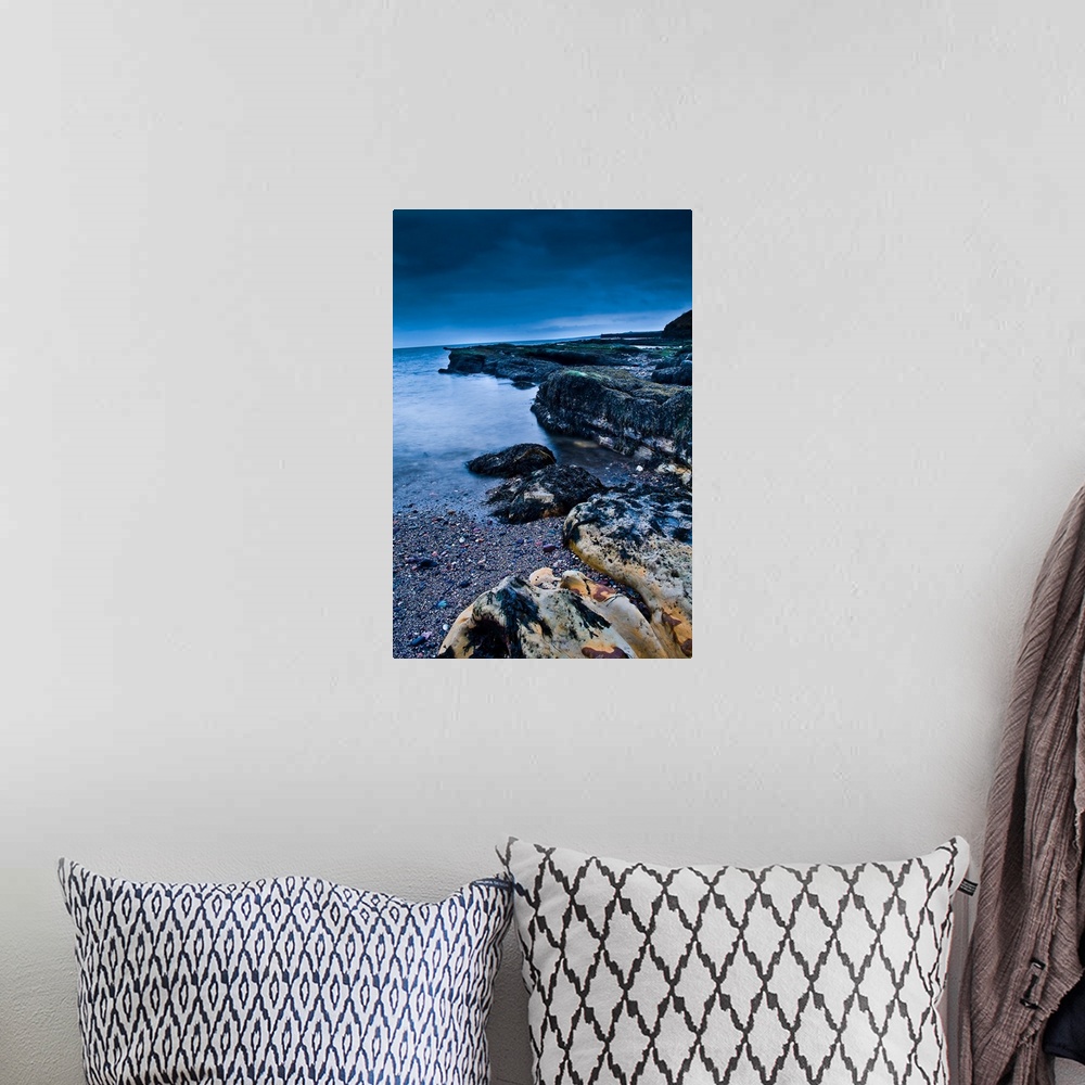 A bohemian room featuring A rocky beach at dusk with storm clouds overhead