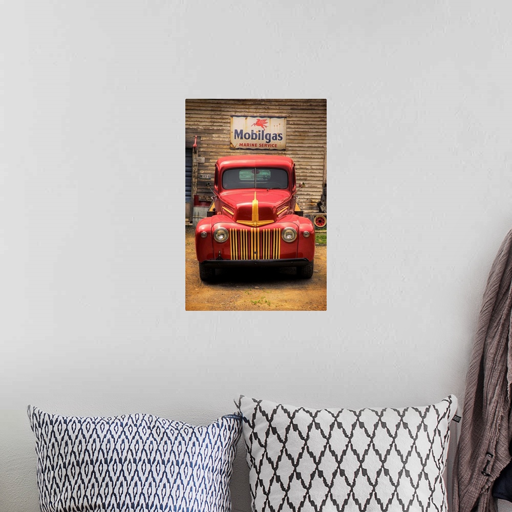A bohemian room featuring Classic old red truck parked in front of a Mobilgas sign.