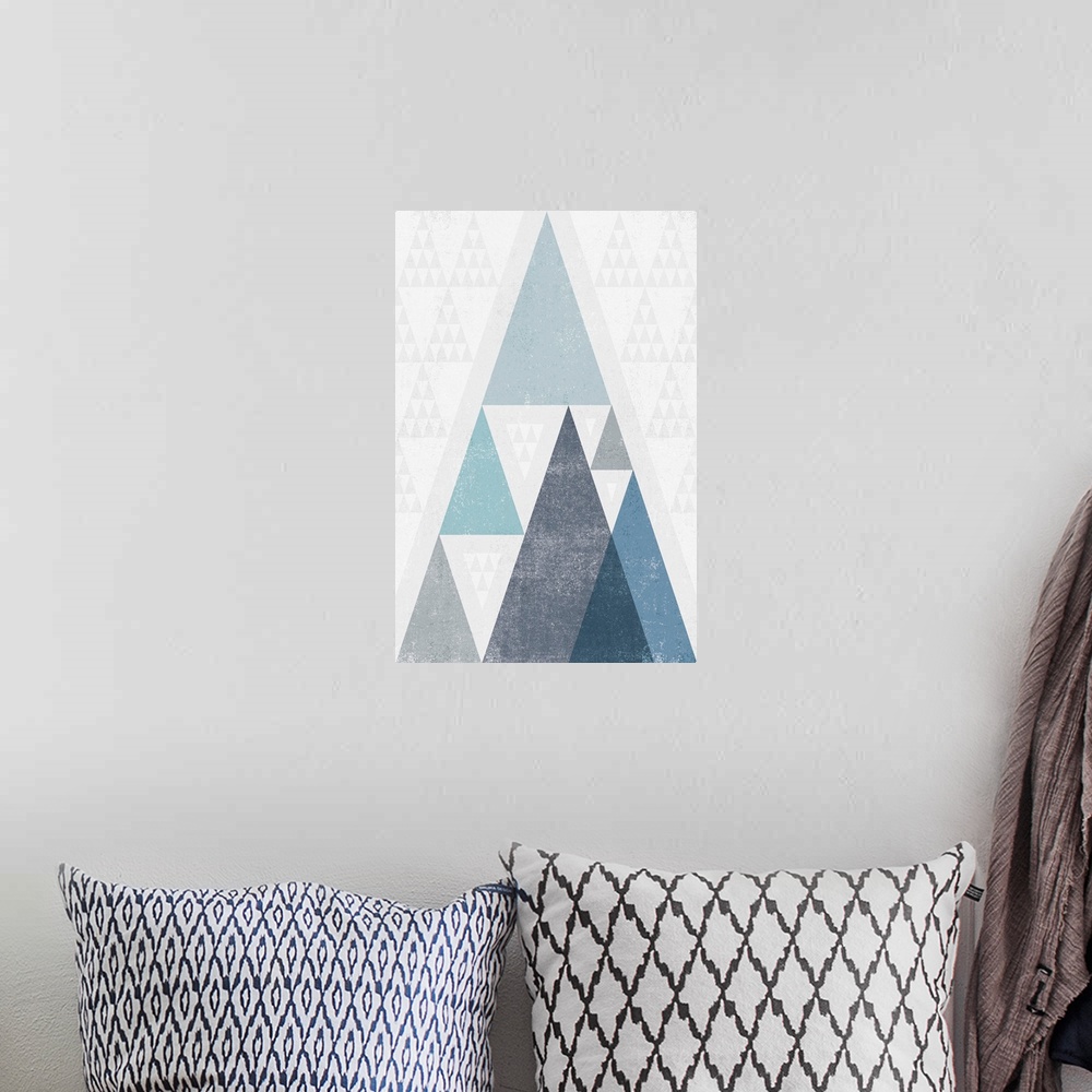 A bohemian room featuring Abstract artwork with a triangle design in cool blue tones.